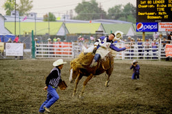 Hatnim Lee, Man on horse with white hat falling at rodeo